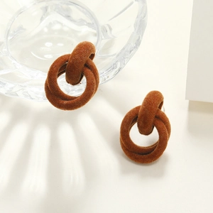 Macro detail of brown flocked interlocking geometric hoop earrings for winter