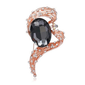 Close-up of luxury brooch with large oval black gemstone and pavé rhinestones in rose gold