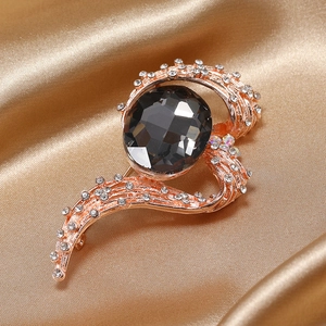 Macro detail of luxury vintage brooch featuring a grey crystal stone on gold silk