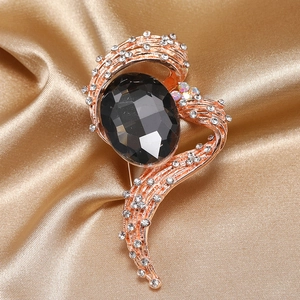Elegant rose gold brooch with large oval black gemstone and crystal pavé details