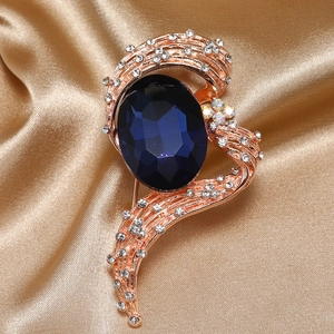 Elegant rose gold brooch featuring a deep blue oval crystal and pavé rhinestones