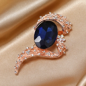 Close-up of elegant rose gold brooch with a large navy blue oval stone and white diamonds