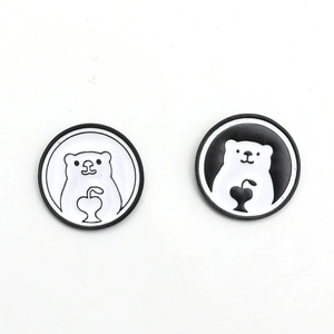 Minimalist black and white enamel polar bear pins with heart motif on white background