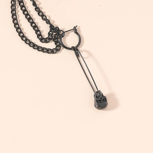 Boucle d'oreille punk noire avec chaîne, épingle à nourrice et crâne sur fond rose