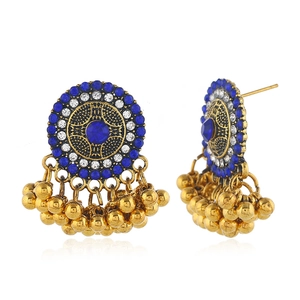 Detail of vintage gold earrings with turquoise stones and tiered metallic bead tassels