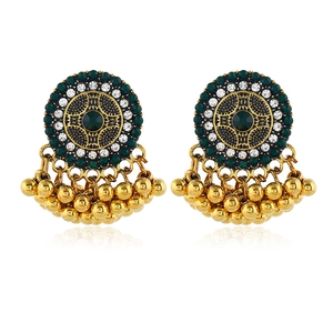 Close-up of bohemian vintage gold earrings with green turquoise and beaded tassels
