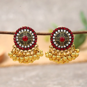 Macro detail of vintage bohemian Jhumka earrings with red stone and golden beads
