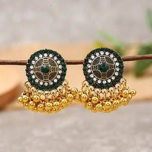 Detail of vintage Jhumka earrings with green rhinestones and golden hanging beads