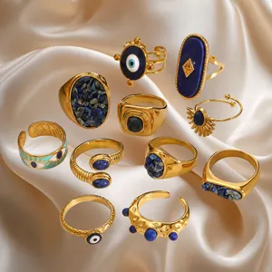 Vintage gold plated ring set with blue stones and evil eye charms on white satin