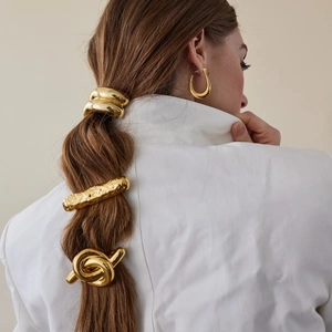 Golden stainless steel hair ties and wavy hair clips set shown on model's ponytail
