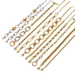 Assortiment de bracelets et colliers cubains en acier inoxydable doré et argenté sur blanc