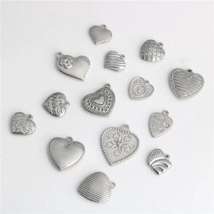 Detailed view of assorted stainless steel heart pendants with various textures and engravings