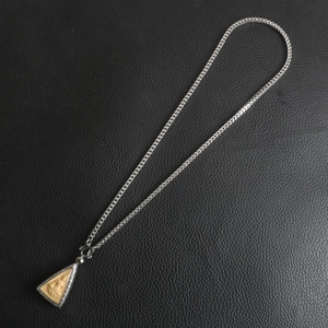 Thai style Buddha amulet pendant necklace with thick silver chain on leather background