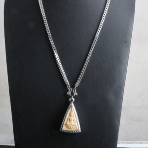 Thai Buddha pendant necklace with silver steel dragon bone chain on display stand