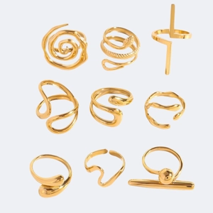Set di nove anelli assortiti in acciaio inossidabile dorato con motivi geometrici e spirali
