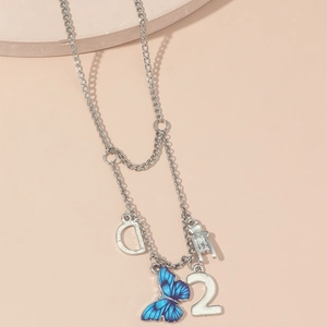 Elegant silver butterfly necklace with letter D and number 2 pendants on beige background