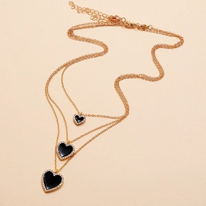 Three-layer gold necklace with heart pendants featuring black enamel and sparkling rhinestones