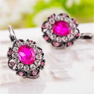 Macro shot of rose red crystal flower earrings with silver filigree and small rhinestones