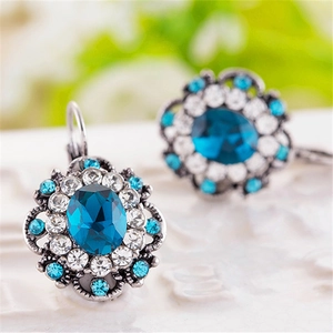 Macro view of vintage silver floral earrings with dark blue crystal and rhinestones