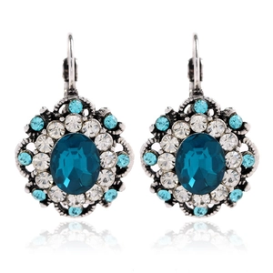 Detailed macro of vintage silver-tone leverback earrings with blue oval crystals and rhinestones