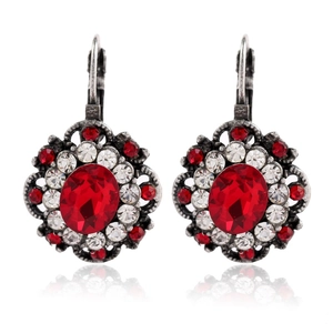 Detail of vintage silver earrings with oval red crystal and sparkling rhinestone border
