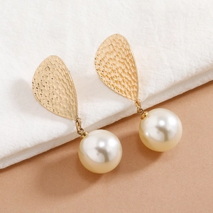 Elegant gold drop earrings with textured metal and large white round pearl pendants