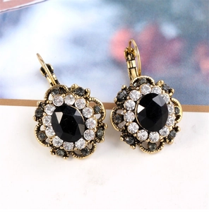 Macro detail of retro lever-back earrings with black oval gemstone and white crystals