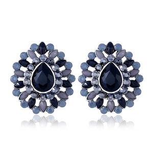 Détail macro de boucles d'oreilles bohèmes en forme de goutte avec résine bleue et strass