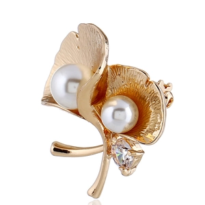 Makrodetail der goldenen Ginkgo-Brosche mit weißen Perlen und funkelndem Zirkon