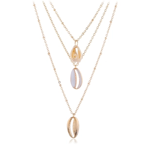 Collana boho a tre strati in oro con ciondoli a conchiglia naturale su sfondo bianco