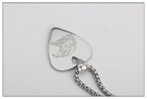 Detailed close-up of polished stainless steel guitar pick pendant with eagle engraving