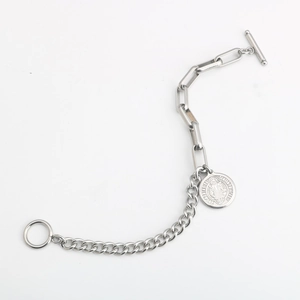Detalle de la medalla de San Benito en una pulsera de acero de titanio con cierre de palanca