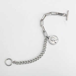 Détail du pendentif pièce Elizabeth II et du fermoir en T sur le bracelet argenté