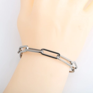Minimalist silver stainless steel paperclip link bracelet on a fashion model's wrist