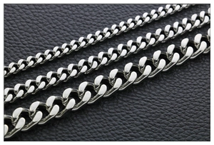Close-up of polished stainless steel cuban link chains in three widths on leather