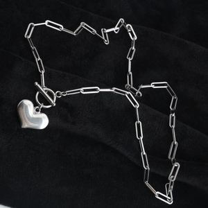 Collana a graffetta argento con ciondolo a cuore e chiusura a T su sfondo nero