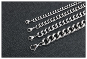 Detalle de cuatro cadenas de eslabones cubanos de acero inoxidable pulido en varios grosores