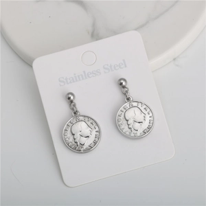 Detailed macro view of silver stainless steel earrings featuring vintage coin reliefs