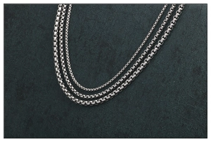 Tres variantes de cadenas box de acero inoxidable pulido sobre fondo de piedra