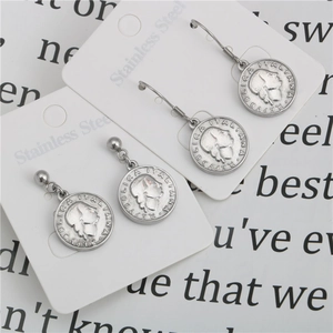 Detailed macro view of vintage Italian coin earrings in polished stainless steel