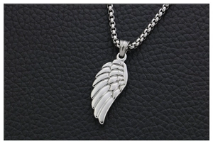 Vue macro du pendentif aile d'ange en argent avec texture plume sur fond en cuir noir