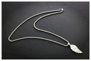 Gros plan détaillé d'un pendentif aile d'ange en argent sur cuir noir