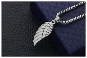 Vue macro d'un pendentif aile d'ange en argent avec détails de plumes fins