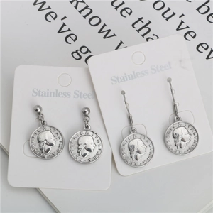 Vintage stainless steel coin earrings featuring embossed queen head relief in silver