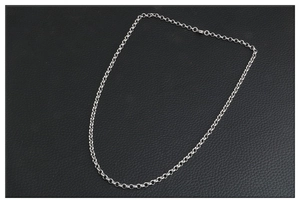 Collier long en acier inoxydable argenté minimaliste sur fond noir à texture de cuir
