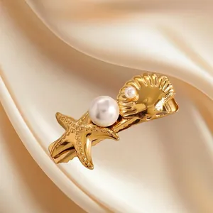 Golden starfish and seashell hair clip with white pearls on champagne silk fabric