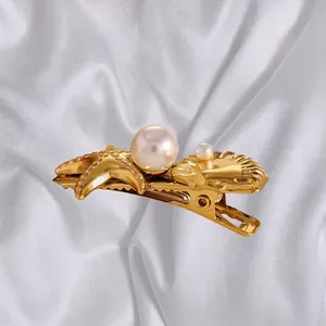 Golden starfish and seashell hair clip with pearls on elegant white satin fabric background