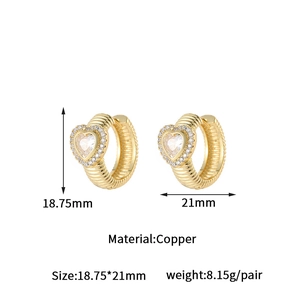 Detail of golden copper heart huggie earrings with zirconia pavé and size dimensions