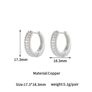 Detailed view of silver hoop earrings with double-row cubic zirconia and beaded texture