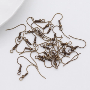 Close-up of bulk bronze fish hook ear wires with spring and bead for DIY jewelry making